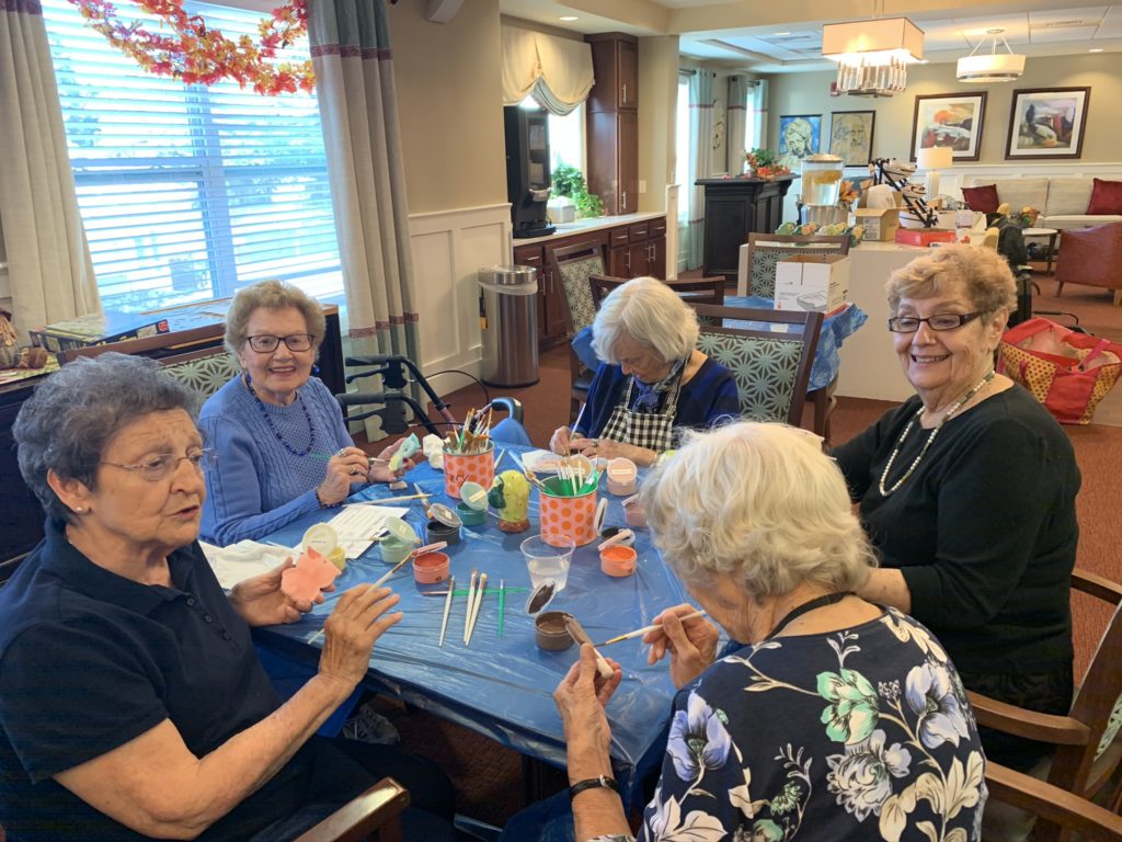 Smiling faces showcasing finished canvas paintings from a fun-filled party in Englewood, NJ